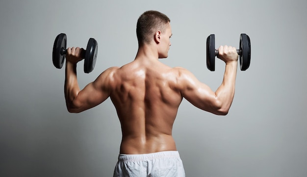 Bodybuilders male back guy doing dumbbell exercises