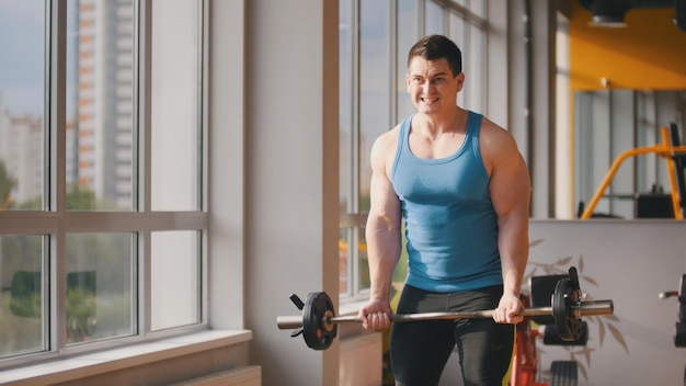 Bodybuilding in the gym - muscular man training his biceps, close up shot