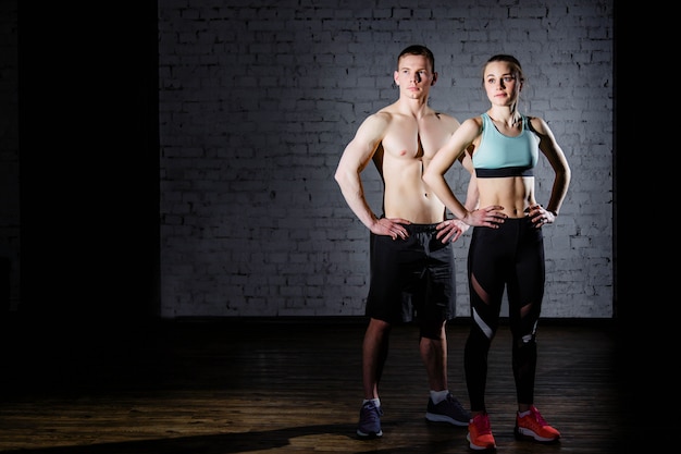 Bodybuilding Sterke man en een vrouw die zich voordeed op een bakstenen muur achtergrond