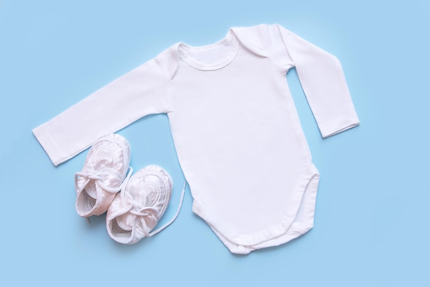 Bodysuit and booties for a newborn on a blue background