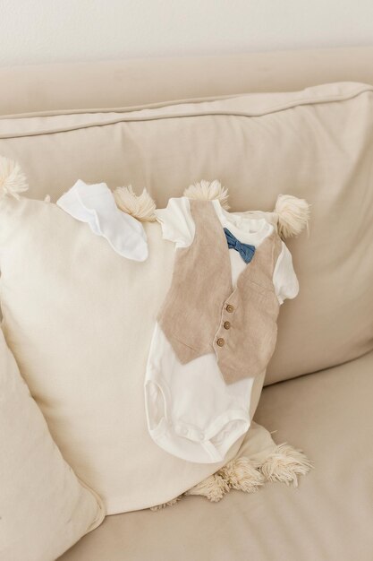 Photo bodysuits and socks for the unborn baby boy on the couch at home closeup