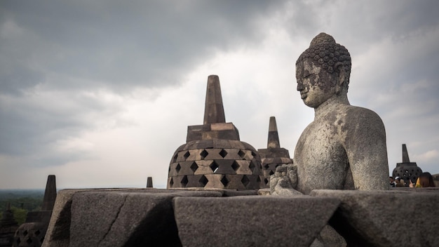 Boeddhabeeld in de tempel tegen een bewolkte lucht