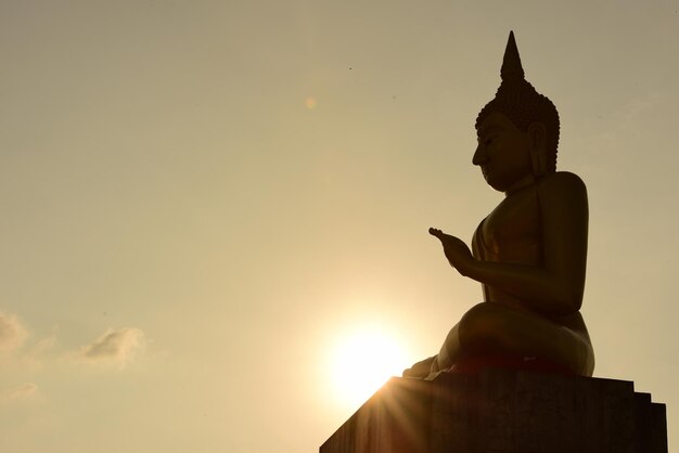 Foto boeddhabeeld tegen de hemel bij zonsondergang