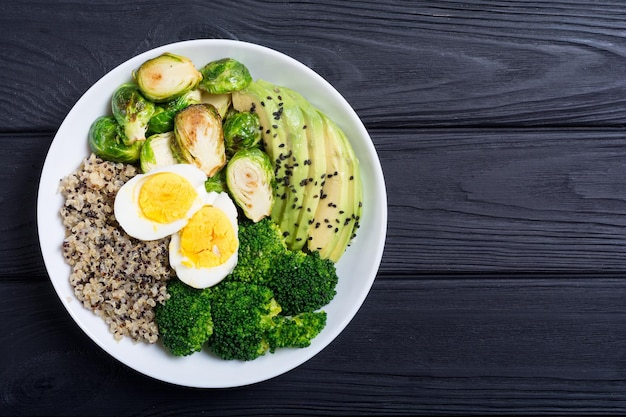 Boeddhakom met quinoa-eieren, avocado-spruitjes en broccoli Voedselveganistische salade op houten achtergrond