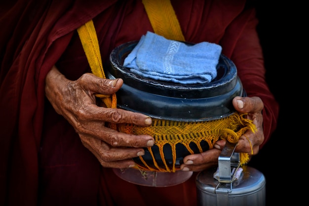 Boeddhistische monnikshanden die aalmoeskom houden