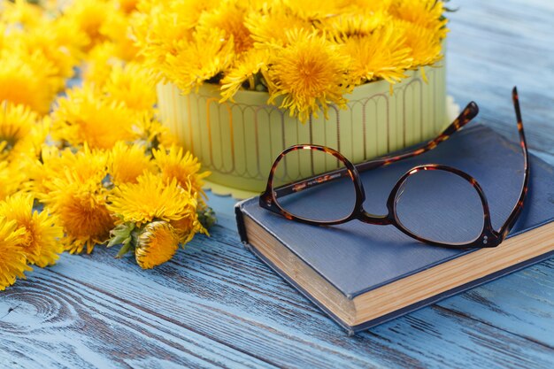 Boek en boeket van paardebloemen