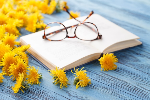 Boek en boeket van paardebloemen