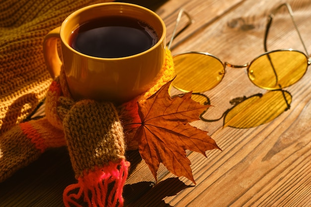 Boek met bril, kopje koffie, herfstbladeren, wollen trui