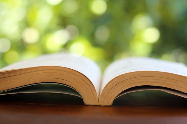 Boek op houten tafel met onscherpe achtergrond.