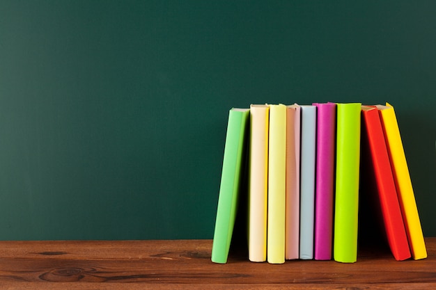 Boeken op bureau, schoolbord