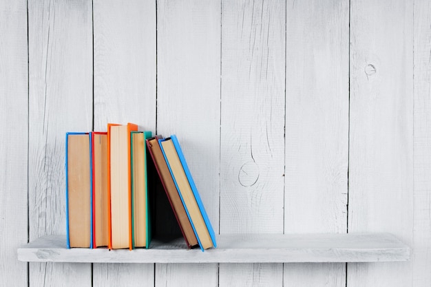 Boeken op een houten plank. Op een houten, witte achtergrond.