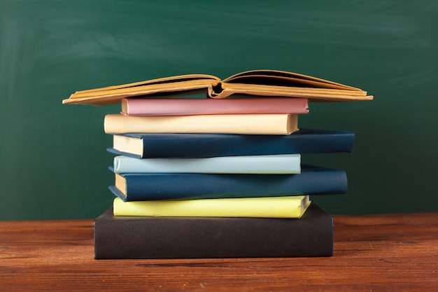 Boeken op het bureau, schoolbord achtergrond