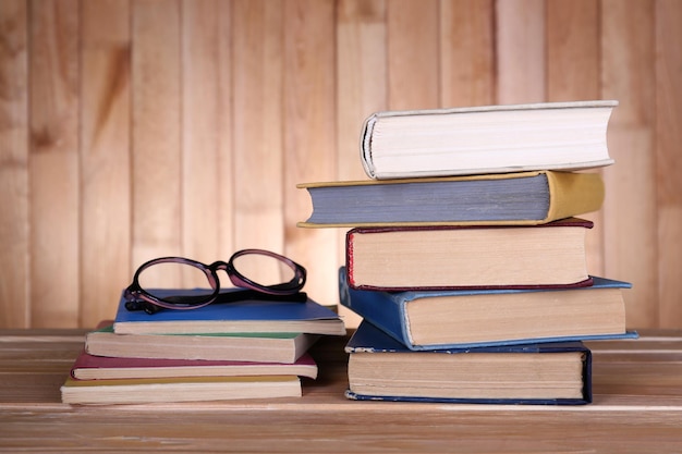 Boeken op houten tafel op houten muur achtergrond