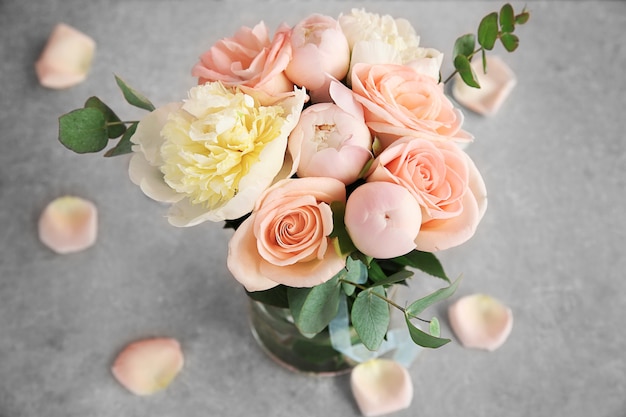 Boeket bloemen in een vaas op een grijze tafel