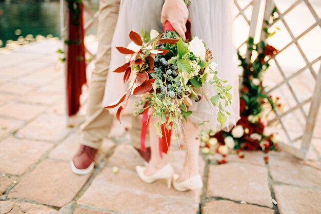 Boeket bloemen vastgebonden met een lint in de hand van de bruid Bijgesneden