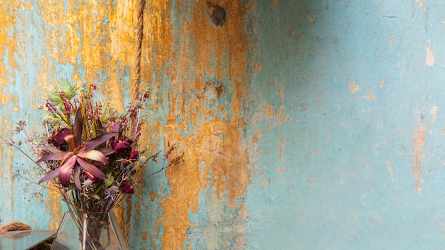 Boeket droogbloemen bij een grunge blauwe muur