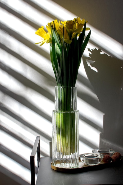 Boeket gele narcissen in een glazen vaas in een aparte tint