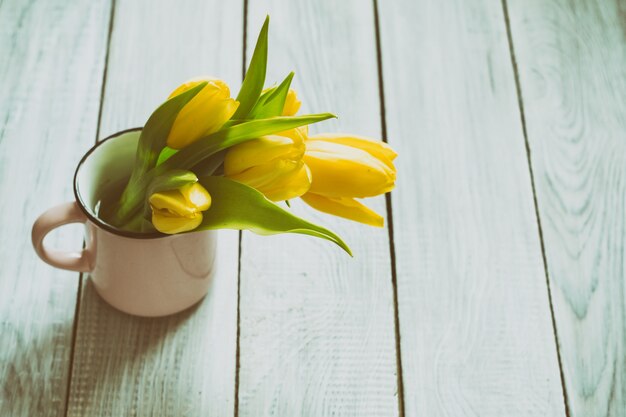 Boeket gele tulpen op een witte houten tafel