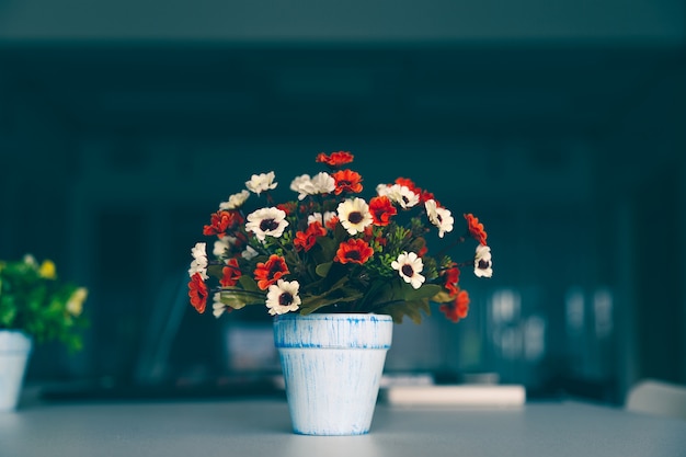 Boeket kleurrijke kunstbloem in vaas op moderne tafel.