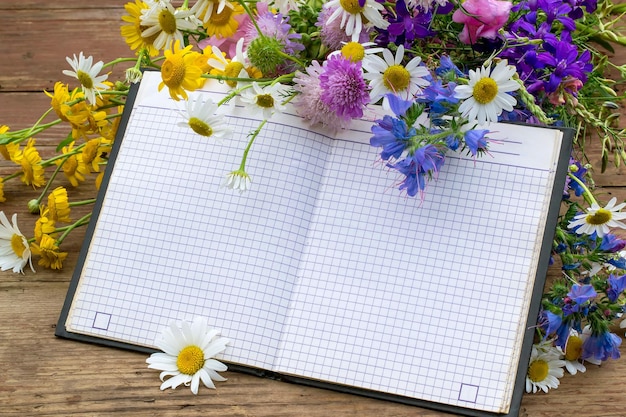 Boeket met wilde bloemen en een notitieboekje om op te nemen