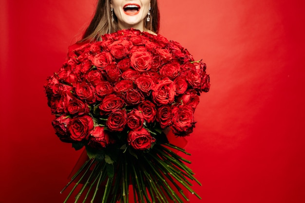 Boeket rode rozen in handen van de vrouw