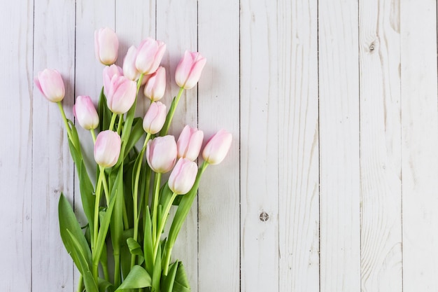 Boeket roze tulpen op een houten ondergrond.