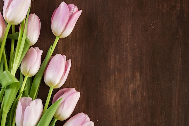 Boeket roze tulpen op een houten ondergrond.