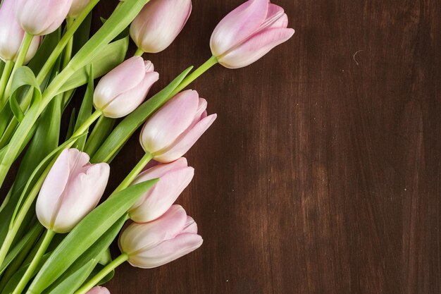 Boeket roze tulpen op een houten ondergrond.