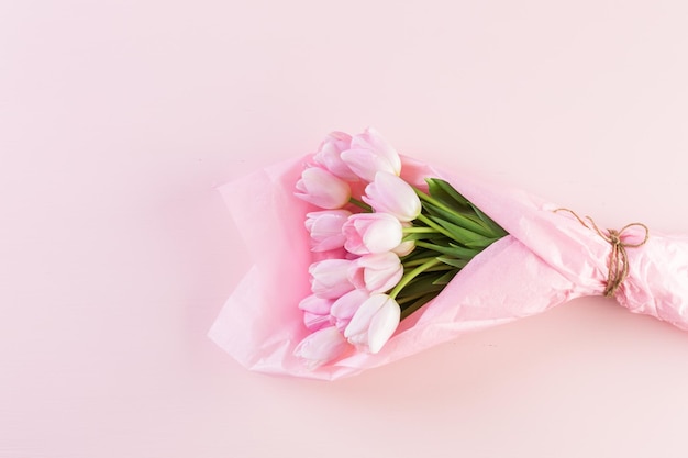 Boeket roze tulpen verpakt in roze papier.