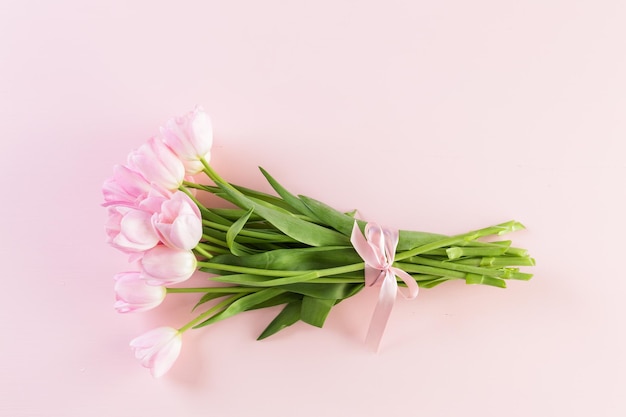 Boeket roze tulpen verpakt in roze papier.