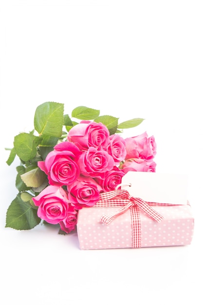 Boeket rozen naast een geschenk met een lege kaart
