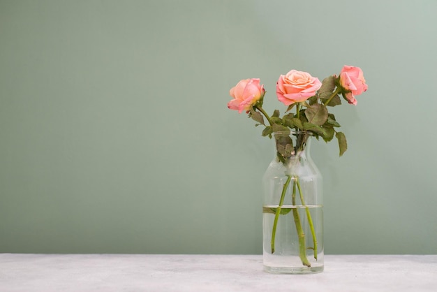 Boeket rozen op een grijze tafel op een groene achtergrond