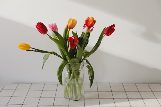 Boeket tulpen in een vaas op tafel thuis