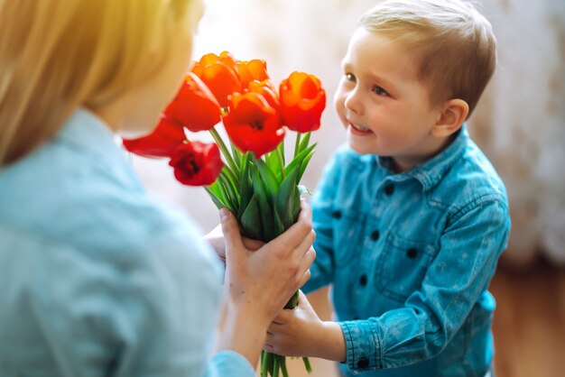 Boeket tulpen voor mama Zoontje feliciteert moeder en geeft een boeket tulpen Blije moeder...