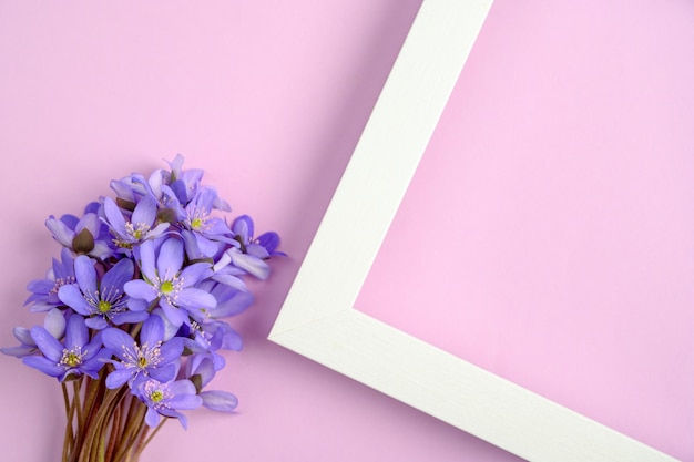 Boeket van blauwe bloemen en wit frame op een paarse achtergrond Bovenaanzicht, kopieer ruimte.