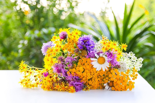 Boeket van boerenwormkruid, margriet en doornige klis wilde zomerbloemen