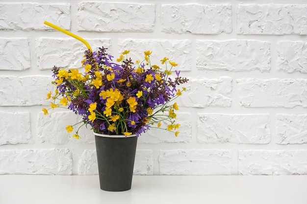 Boeket van gekleurde bloemen op witte bakstenen muur