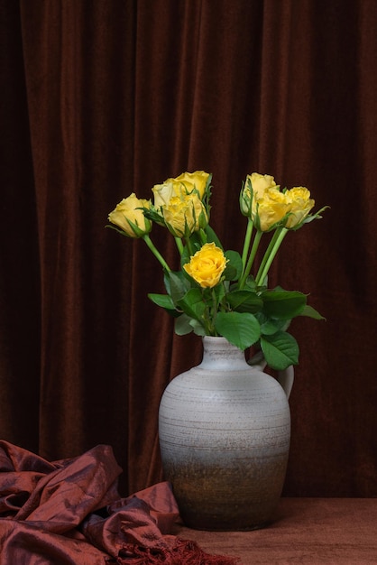 Boeket van gele rozen op een achtergrond van een donkere stof stilleven