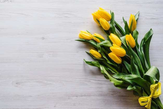 Boeket van gele tulpen op witte houten achtergrond met ruimte voor bericht zomer bloemen concept lente vakantie wenskaart voor Valentijnsdag Women's Mother's Day Pasen bovenaanzicht plat lag