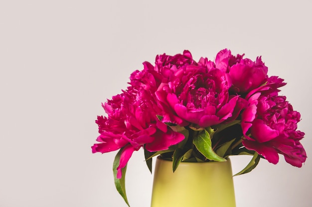 Foto boeket van helder roze pioenrozen in een vaas