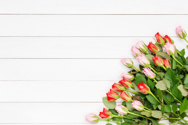 Boeket van kleine rozen op witte houten achtergrond. Bovenaanzicht, kopie ruimte