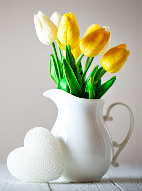 Boeket van lente tulpen op een lichte muur