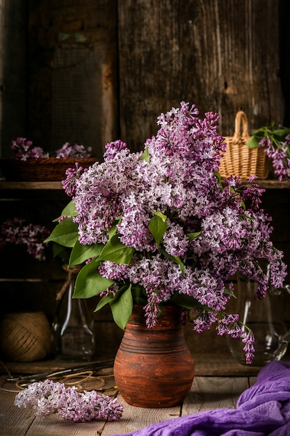 Boeket van lila bloemen in een keramische pot op oude tafel