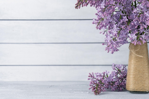 Boeket van lila bloemen in vaas op grijze houten achtergrond Kopieer ruimte voor backdrop