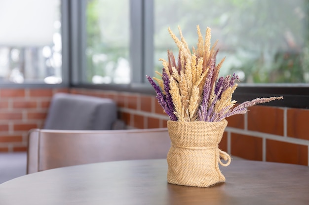 Boeket van mooie droge planten in een moderne vaas op houten tafel voor huisdecoratie