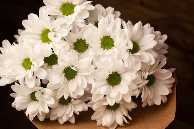 Foto boeket van mooie witte chrysanten in ambachtelijk papier.