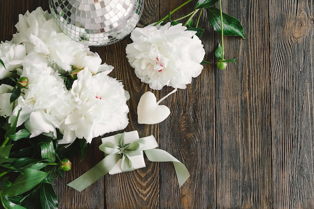 Boeket van mooie witte pioenrozen met geschenkdozen op houten achtergrond Stijlvolle bloemengroeten Moederdag