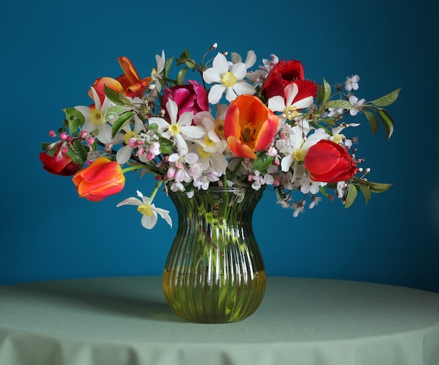 Boeket van narcissen en tulpen op de tafel.