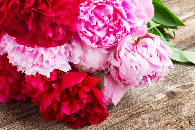 Boeket van rode en roze pioenrozen op houten tafel