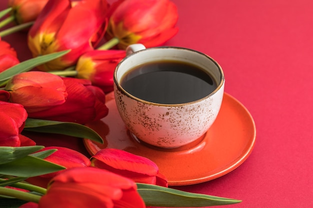 Boeket van rode tulpen en koffiekopjes met veel kopieerruimte voor tekst